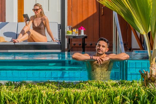 Ein Paar, das seine Zeit am Pool der eigenen Villa genießt