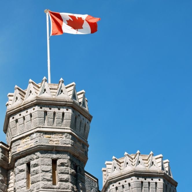 Exterior of a stone building with a Canadian flag
