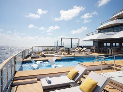 Lounge chairs around a pool on a yacht deck