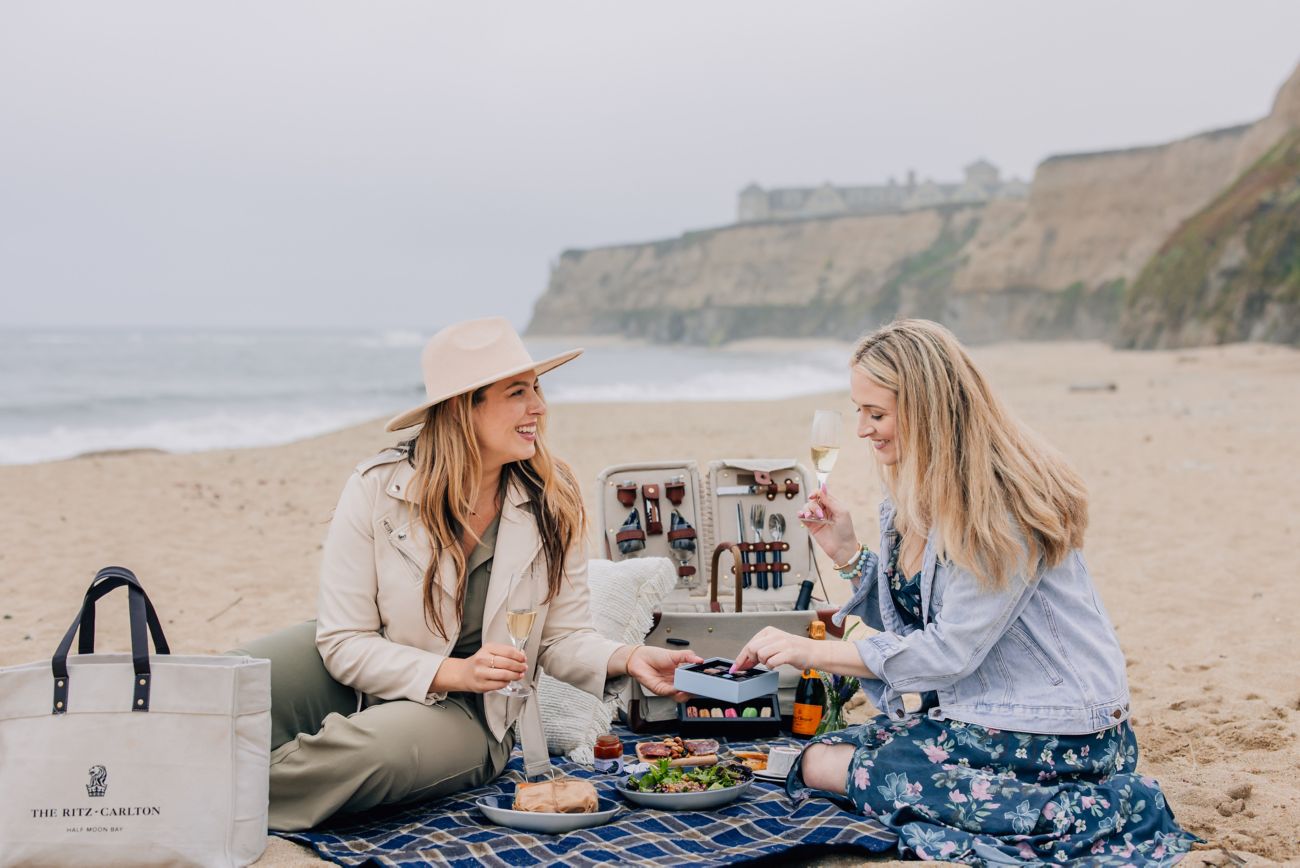 Ladies enjoying a picnic on the beach with champag