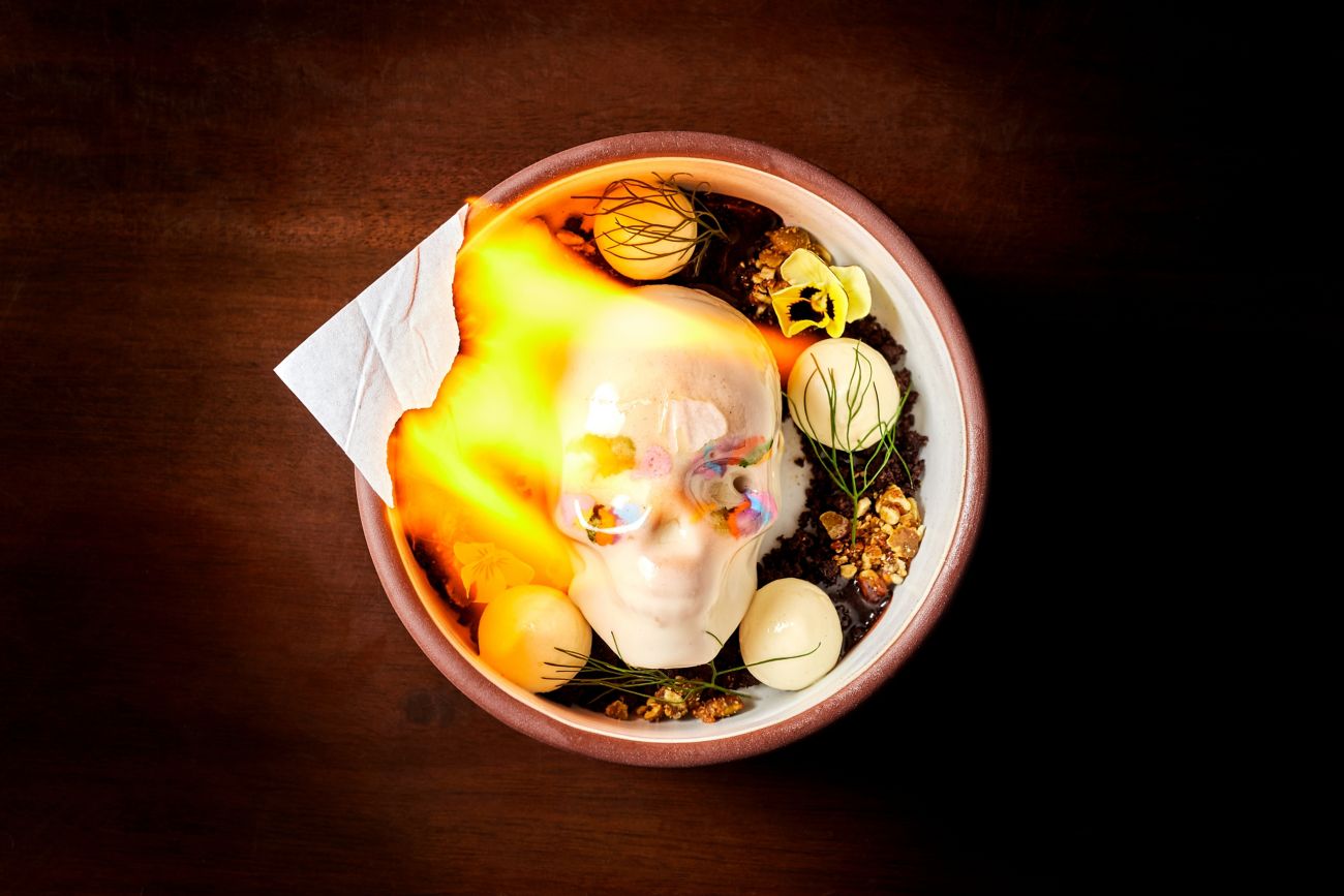 A bowel with a chocolate skull and lit flame.