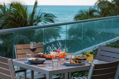 outdoor dining table with views of ocean and palms