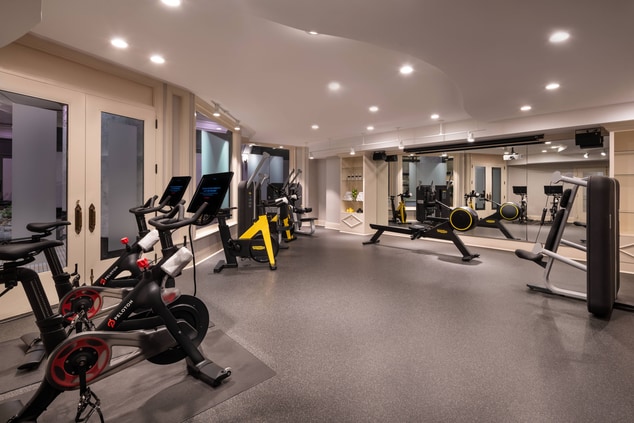 A fitness center with a rowing machine and Peloton