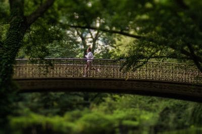 woman jogging on bridge in Central Park.