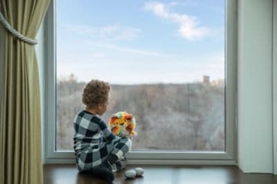 Kid with toy by the window