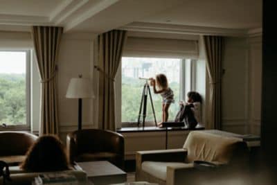 two children looking out of hotel suite window 