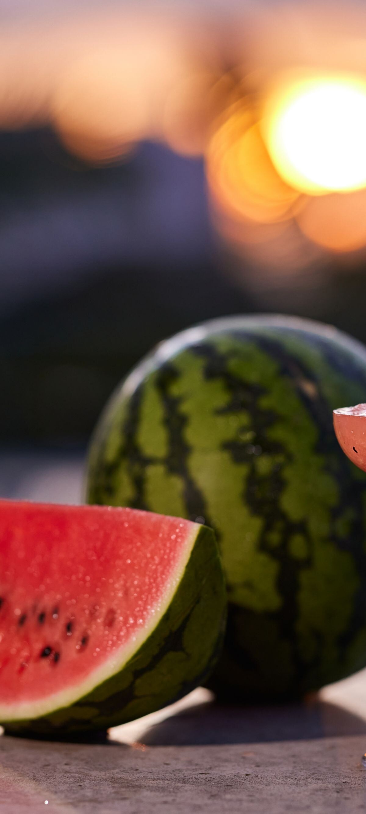 Watermelon cocktail and sliced fruit at sunset