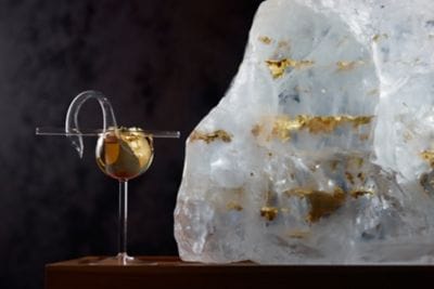 Cocktail in a glass shaped as a swan with gold