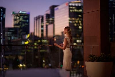 Guest facing the Perth city skyline at dusk 
