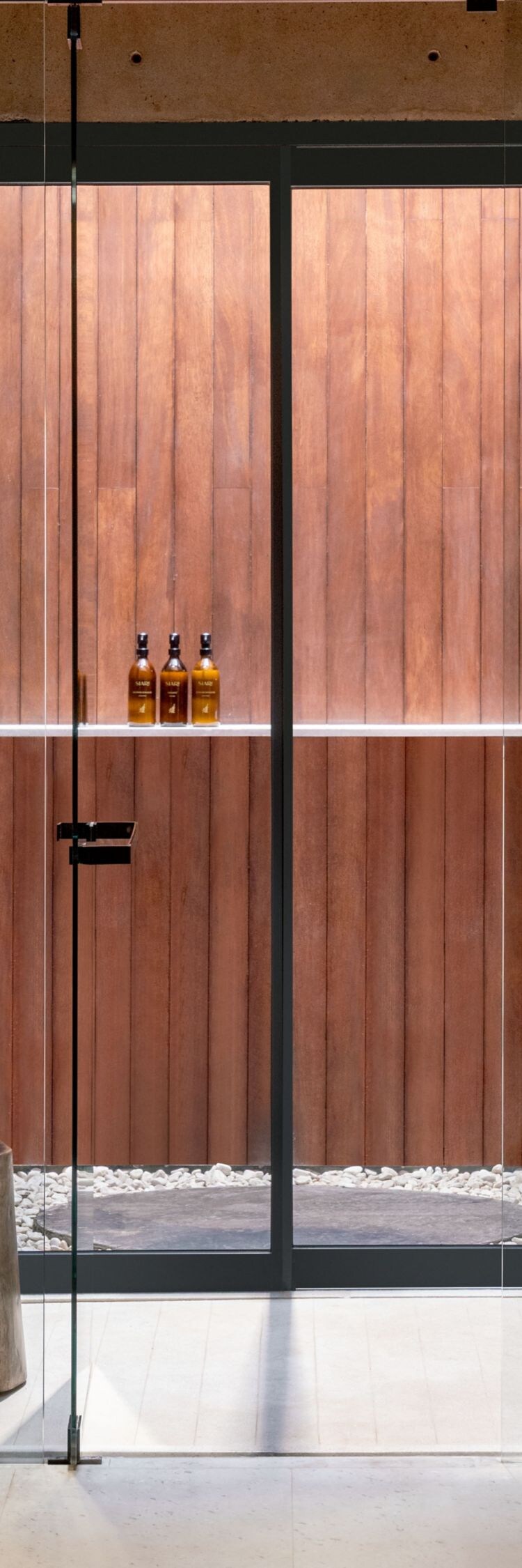 glass‑enclosed shower with wooden decoration