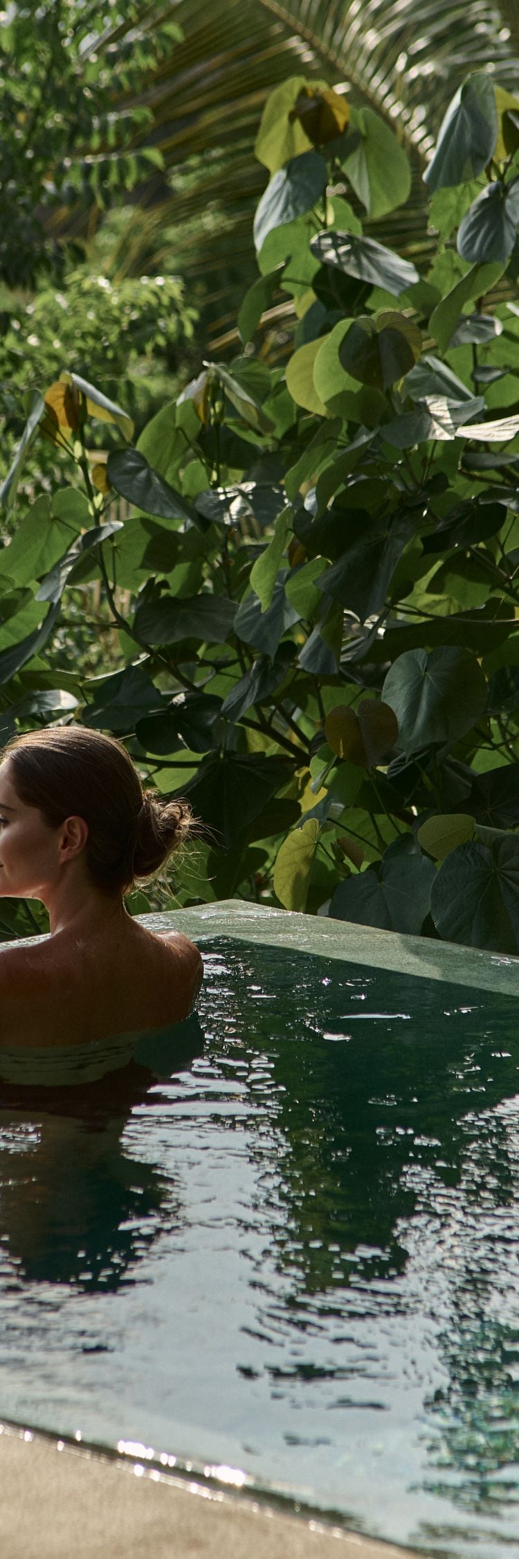Mujer en la piscina de inmersión junto al océano