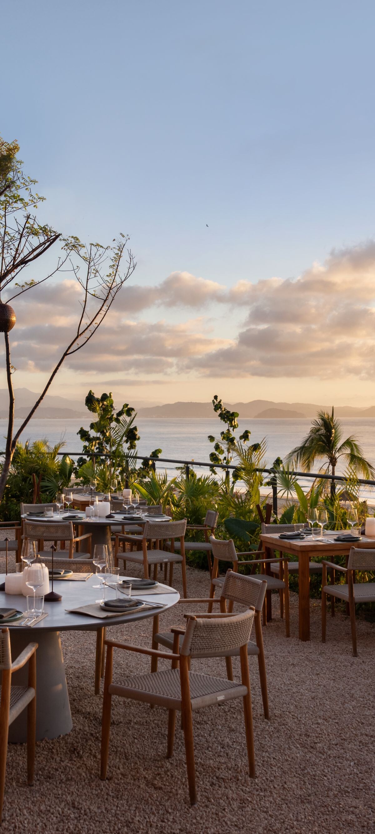 tables and chairs on outdoor terrace at sunset