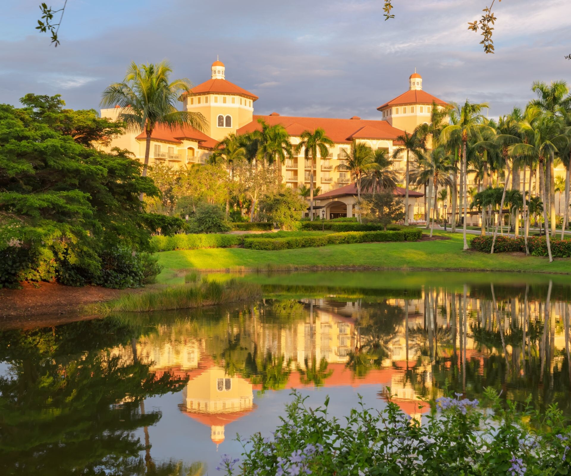 Resort exterior with pond and palm trees