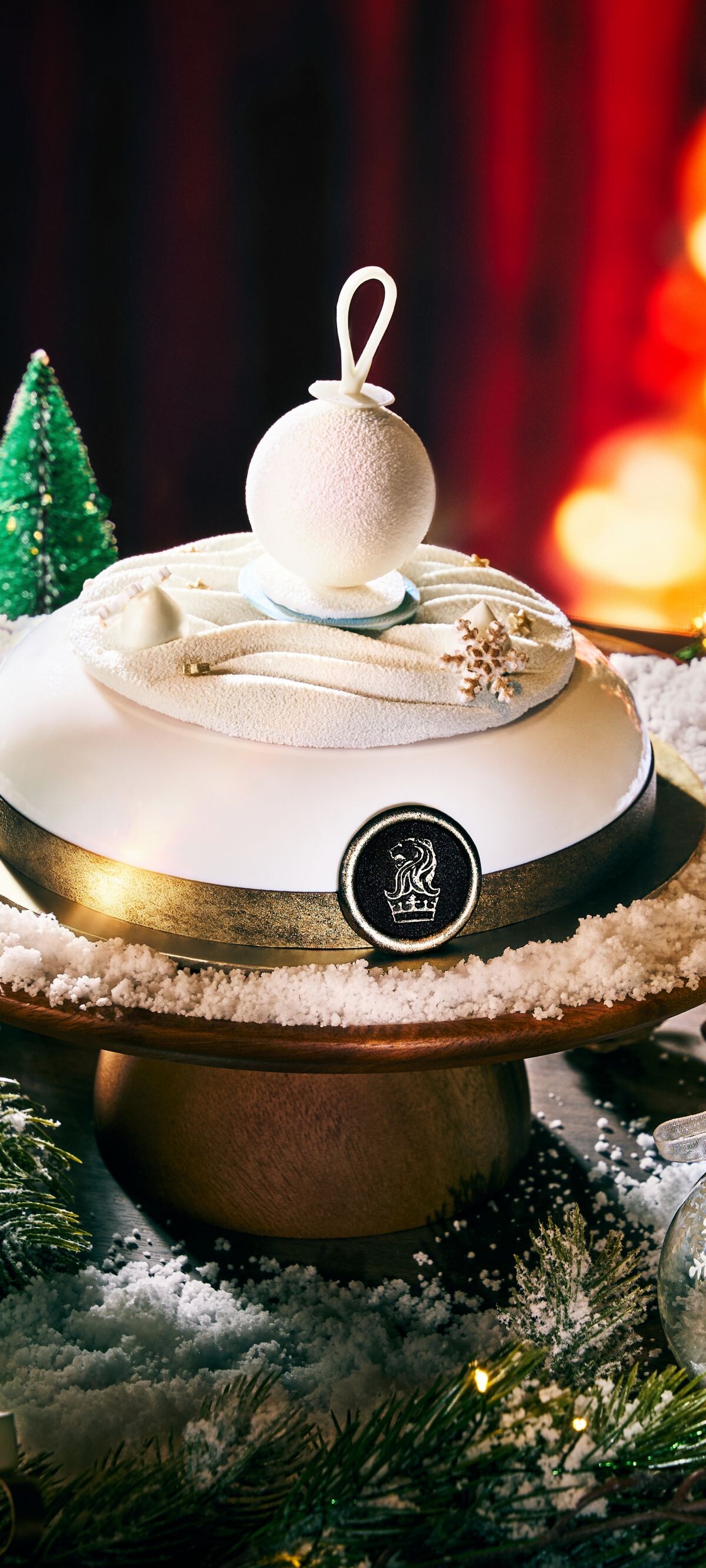 A white christmas cake topped with a white bauble