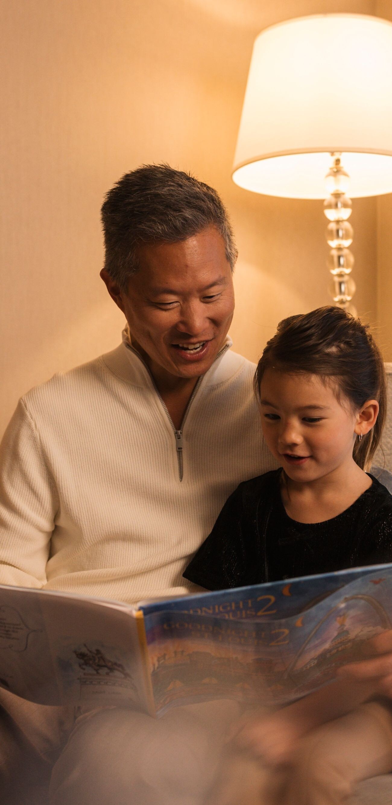 Father daughter reading by Christmas tree