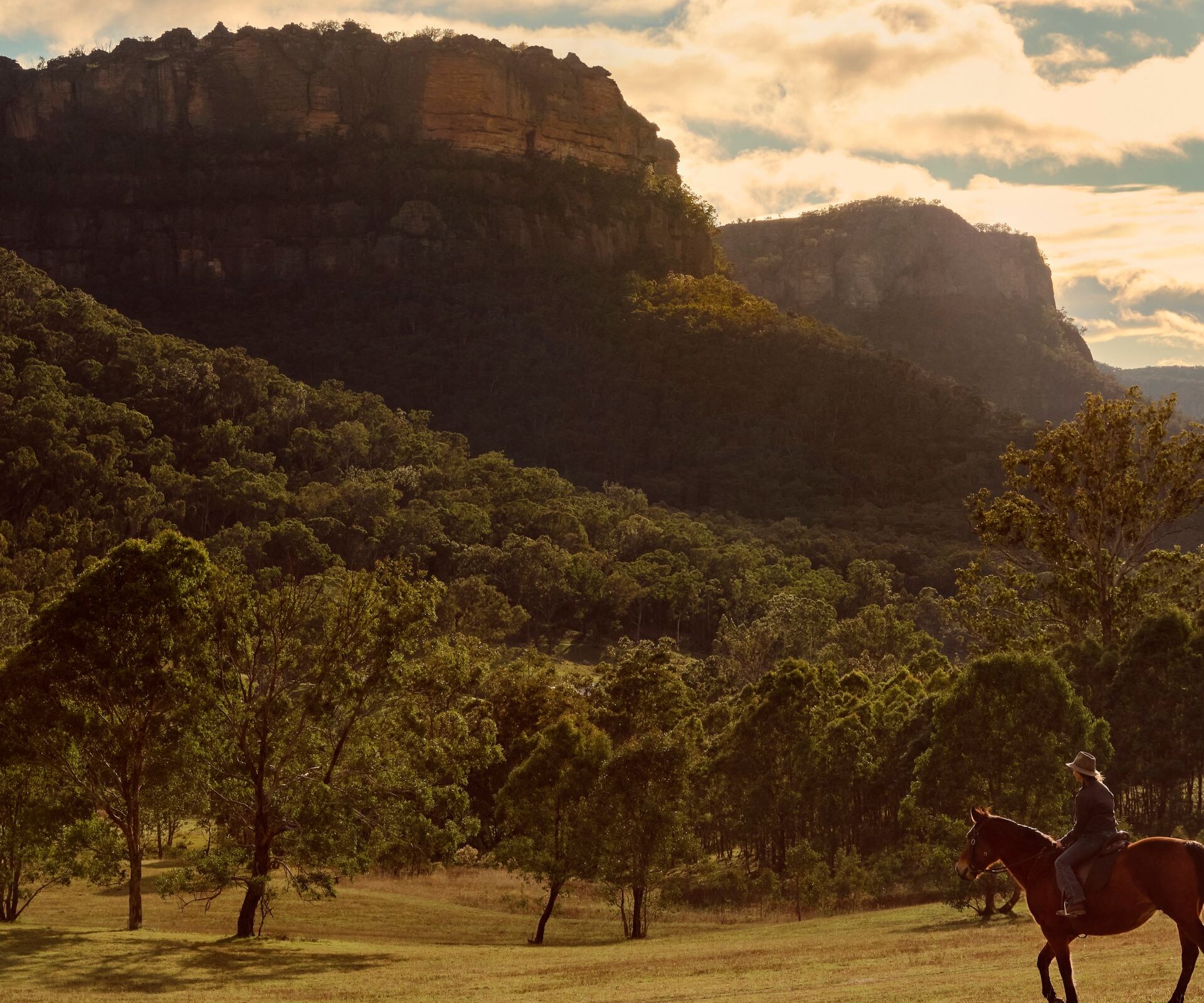 Riders beneath sandstone escarpments