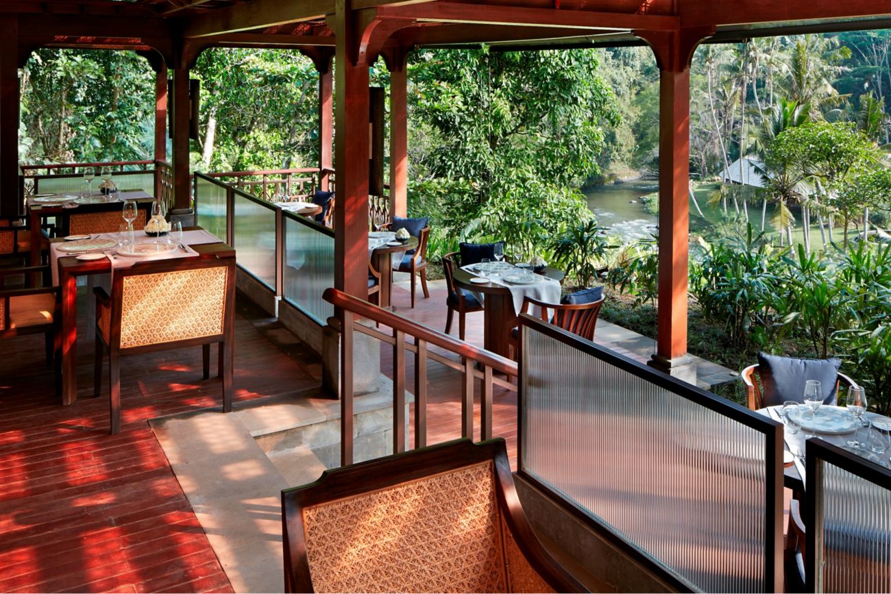 Table for two set on an outdoor terrace overlooking the Ayung River and rainforest
