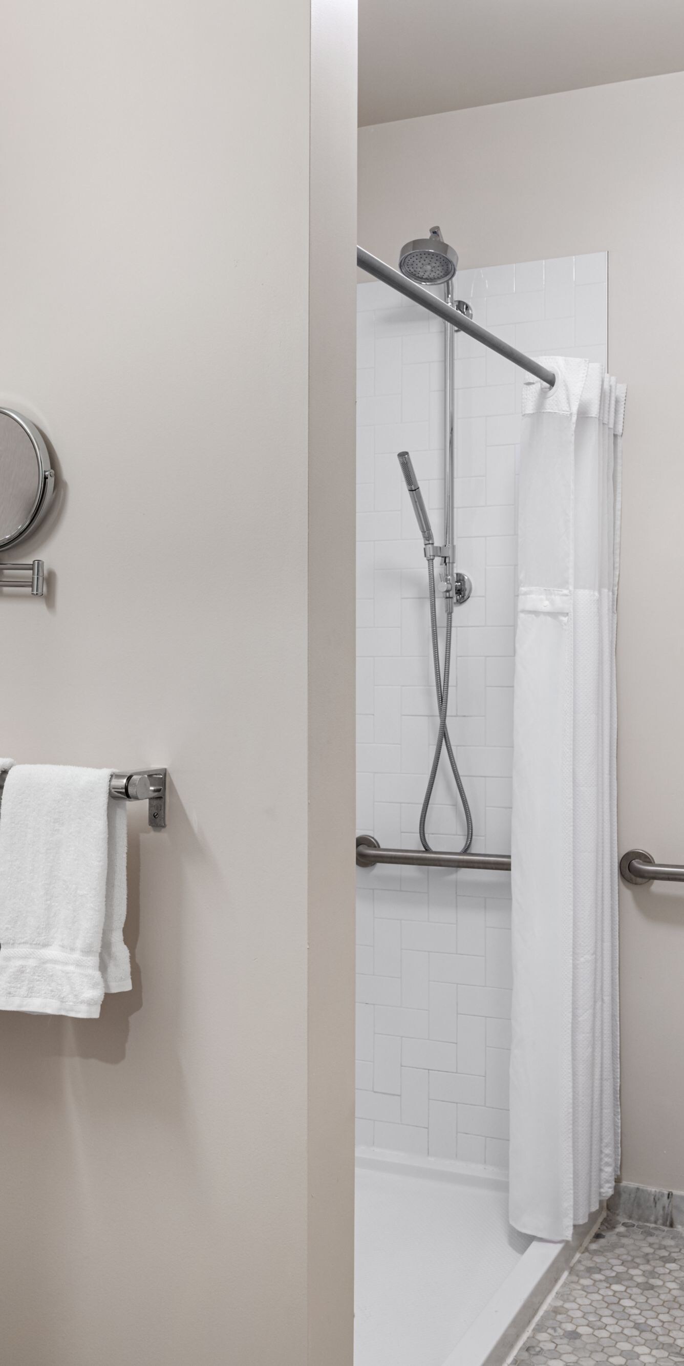 shower with grab bars, toilet, and sink
