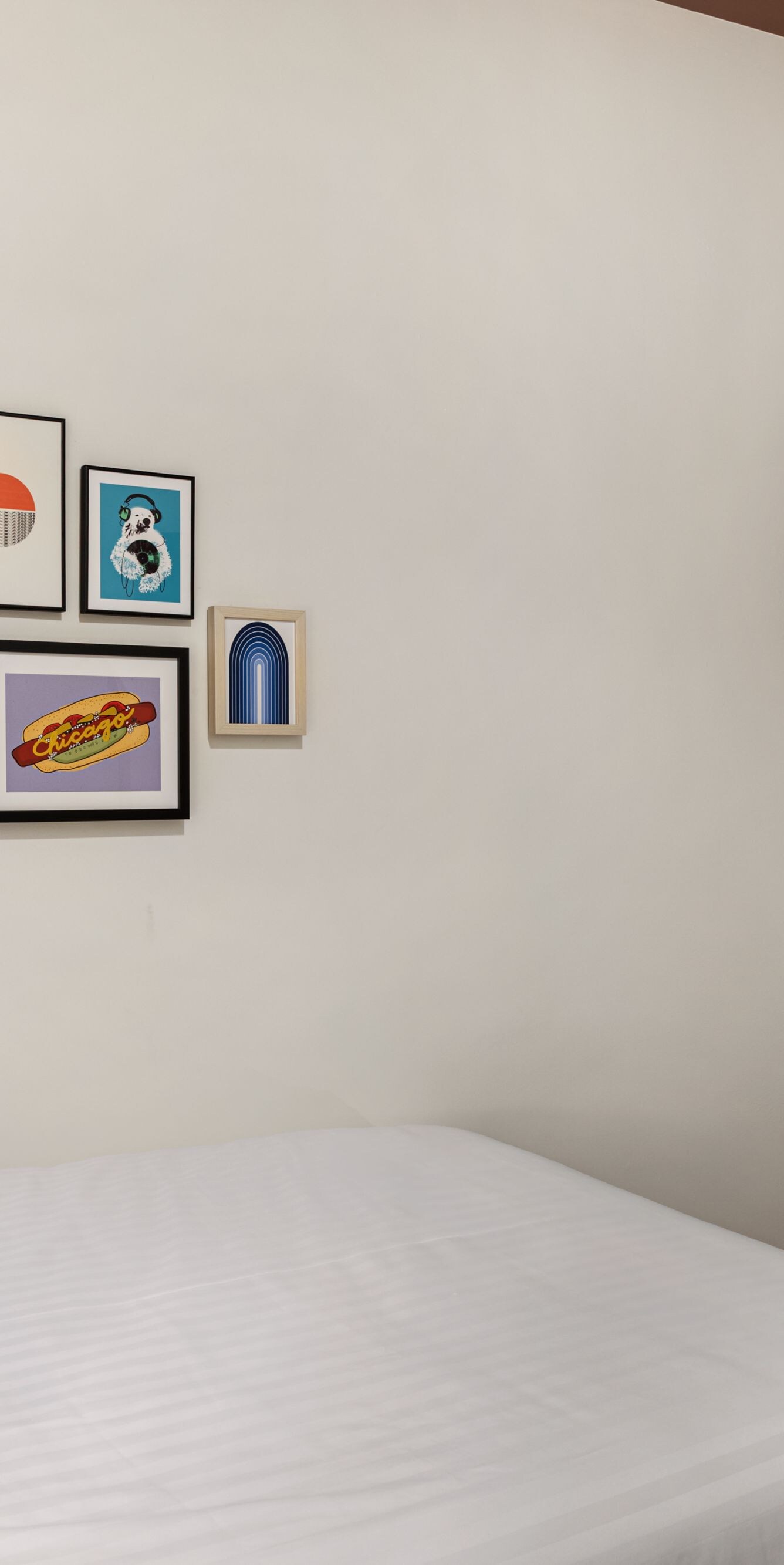 queen bed, desk, tv, and artwork