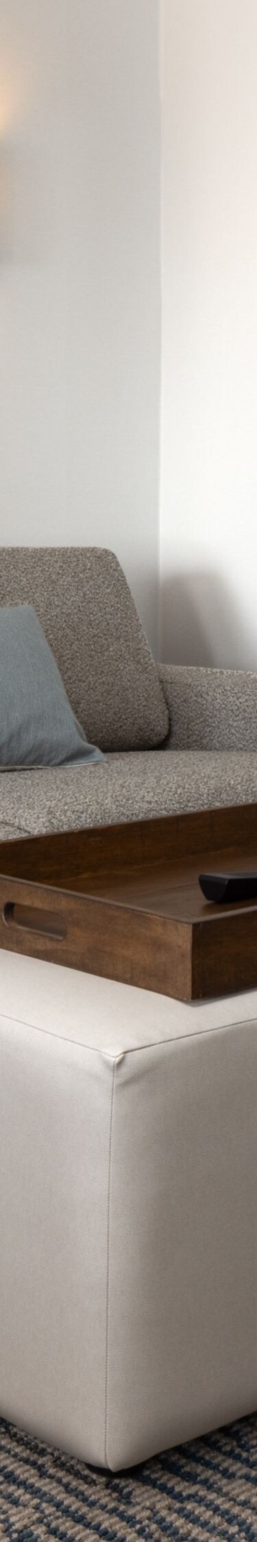 Guest room seating area with sofa and ottoman
