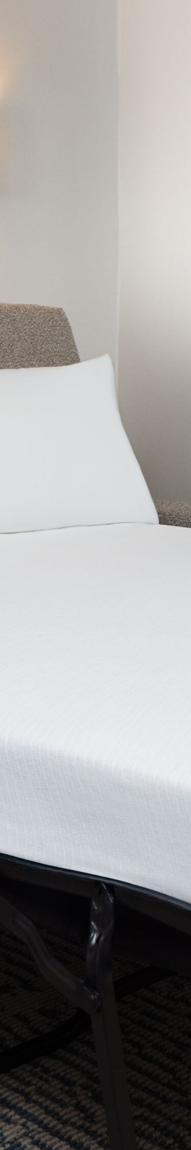 Sofa bed with white linens and wall art