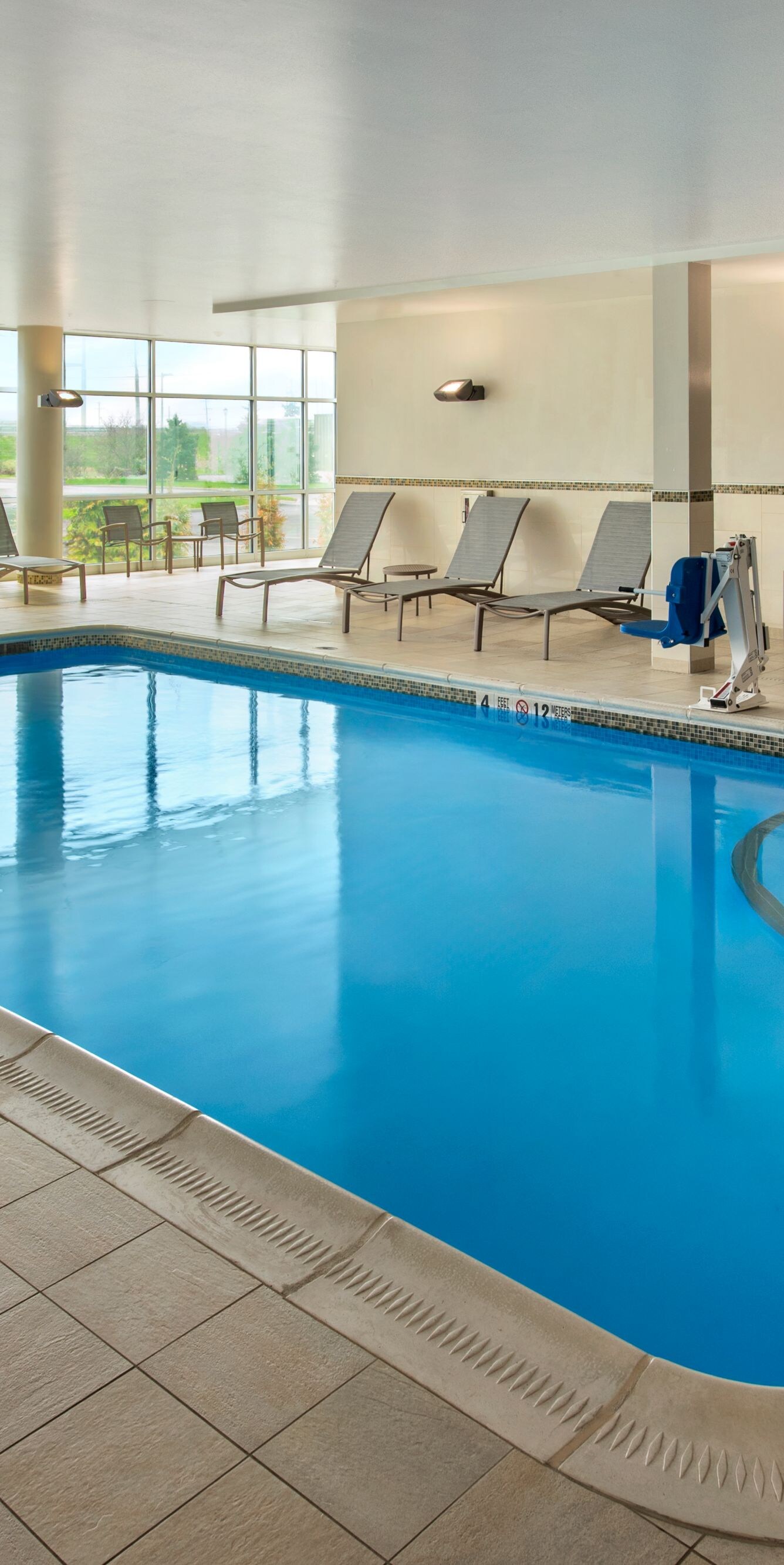 Indoor swimming pool with poolside lounge chairs