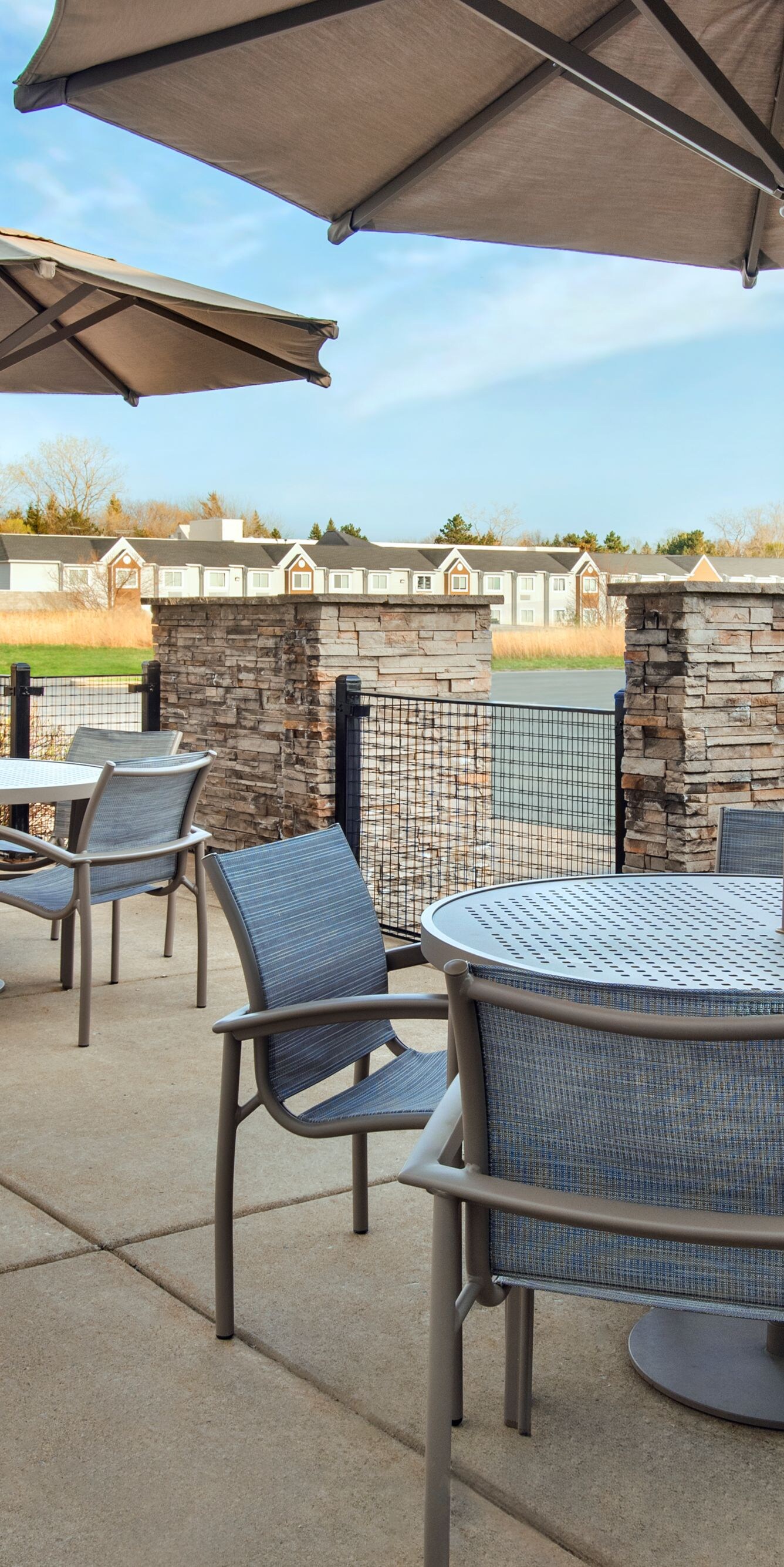 patio with tables, chairs, umbrella-covered seats