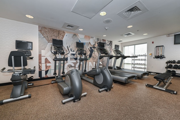 fitness room with cardio equipment and weights