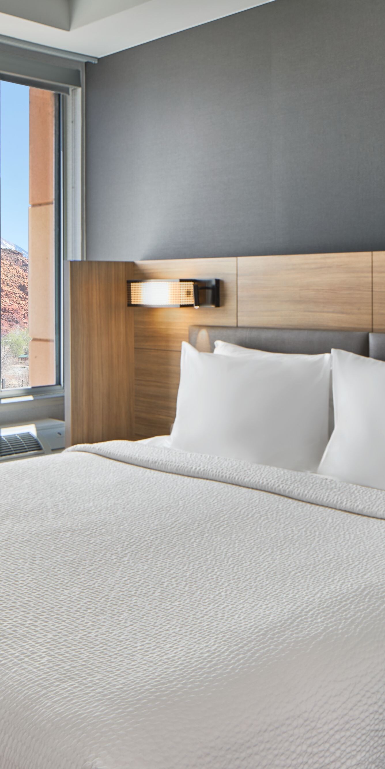 Guestroom bed near window with view of hills
