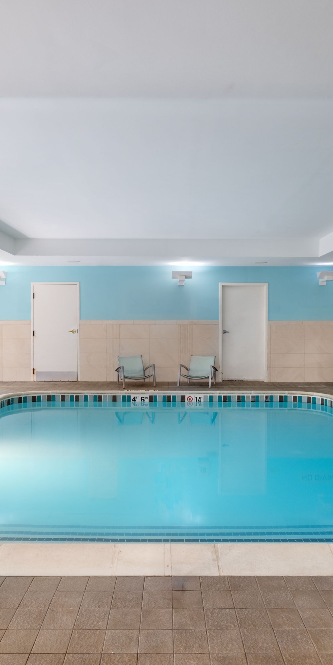 Indoor pool with lounge chairs and pool lift