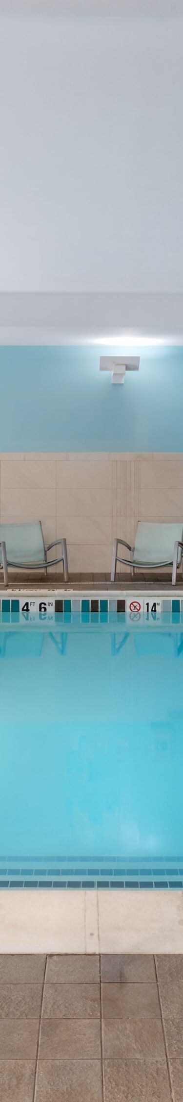 Indoor pool with lounge chairs and pool lift