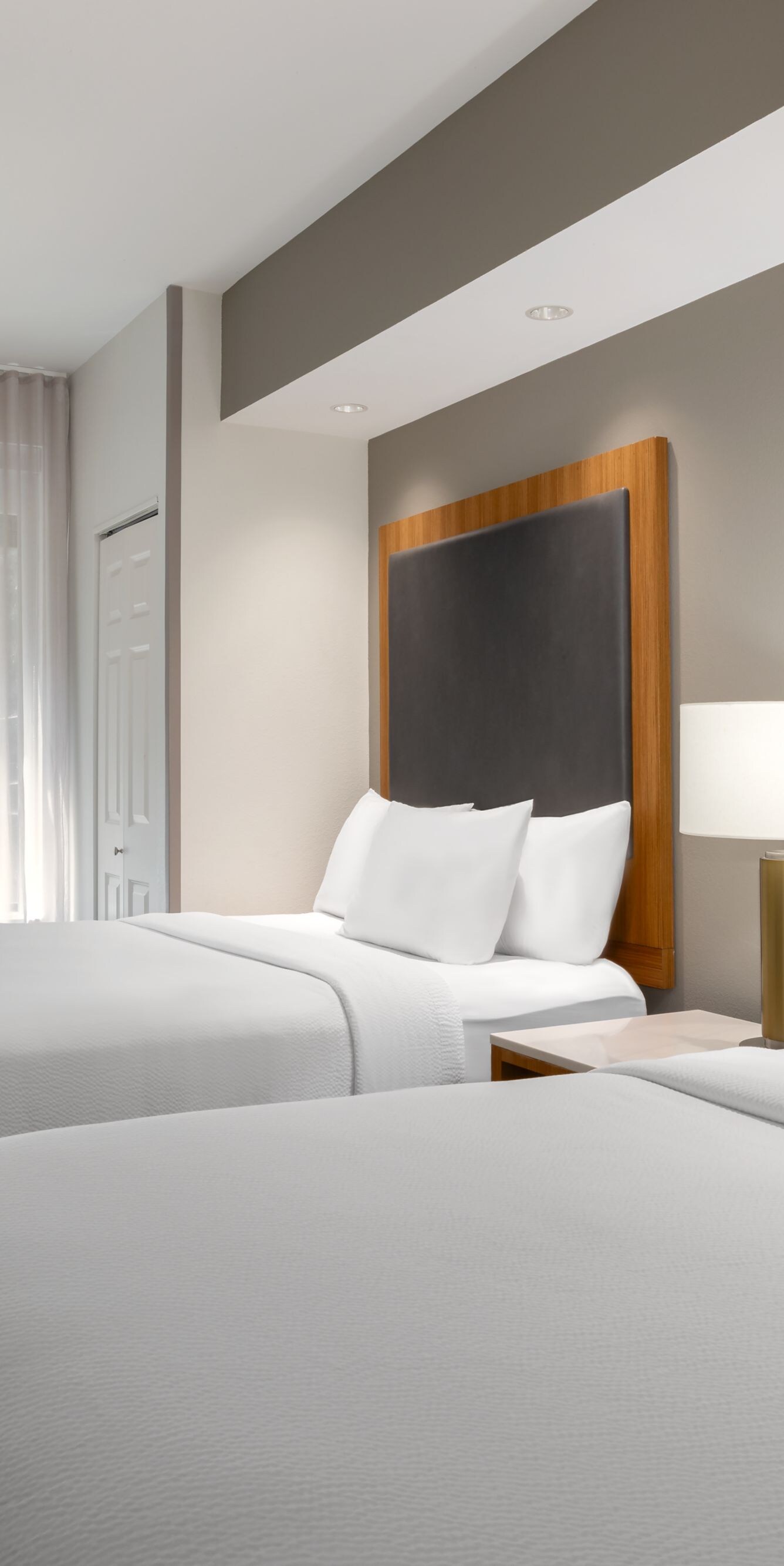 Two queen beds with window and nightstand