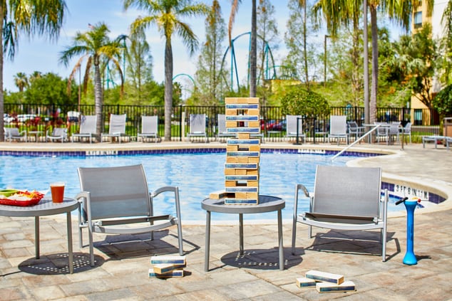 giant game of jenga next to pool with large drink