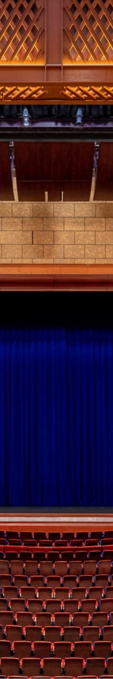 Theater with empty stage and curtain closed.