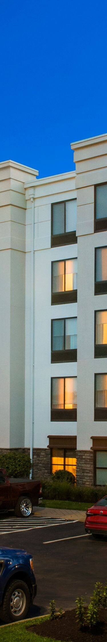Exterior of hotel and parking lot at night