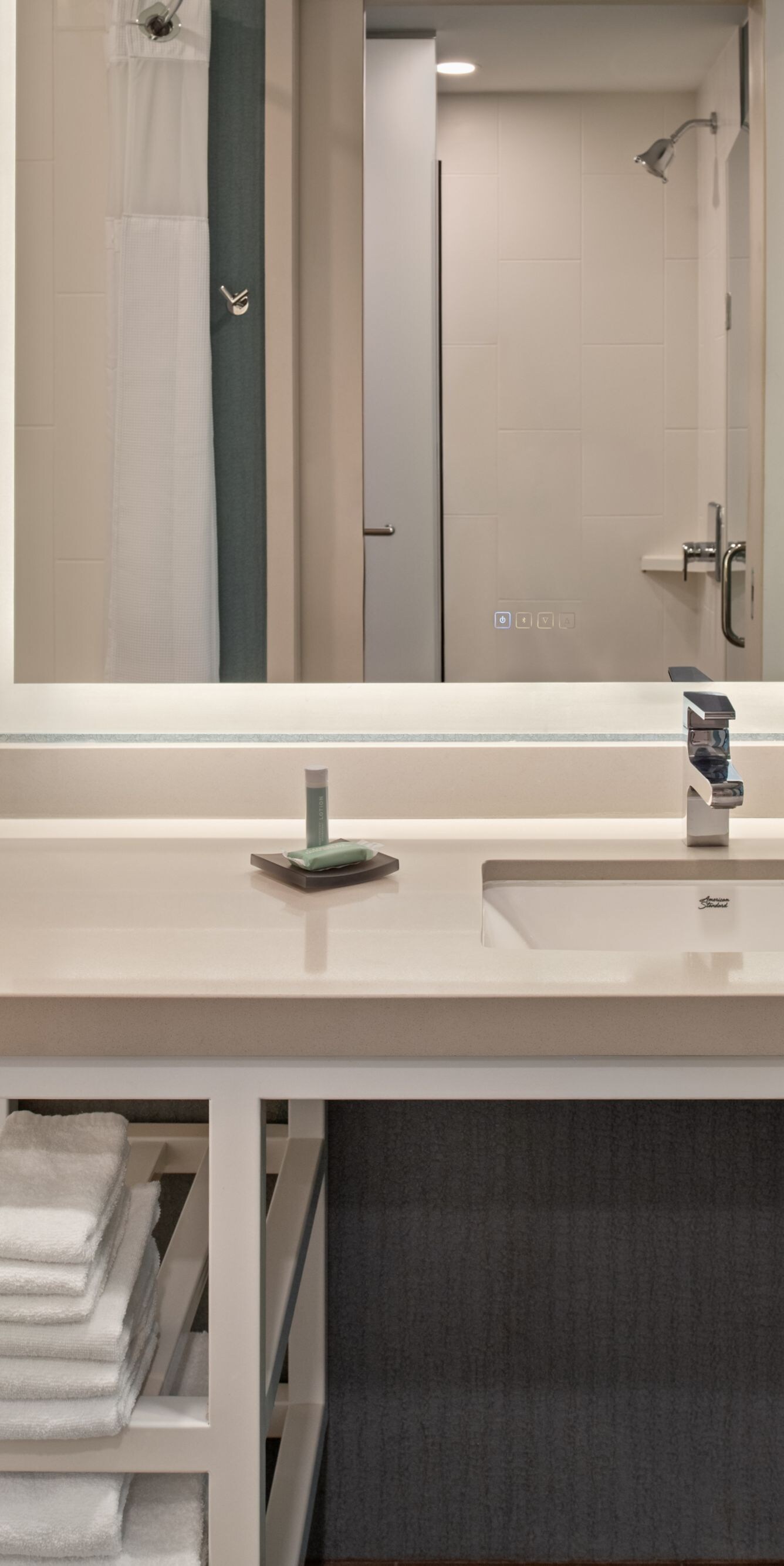 Vanity, tub, towels, toiletries in guest bathroom