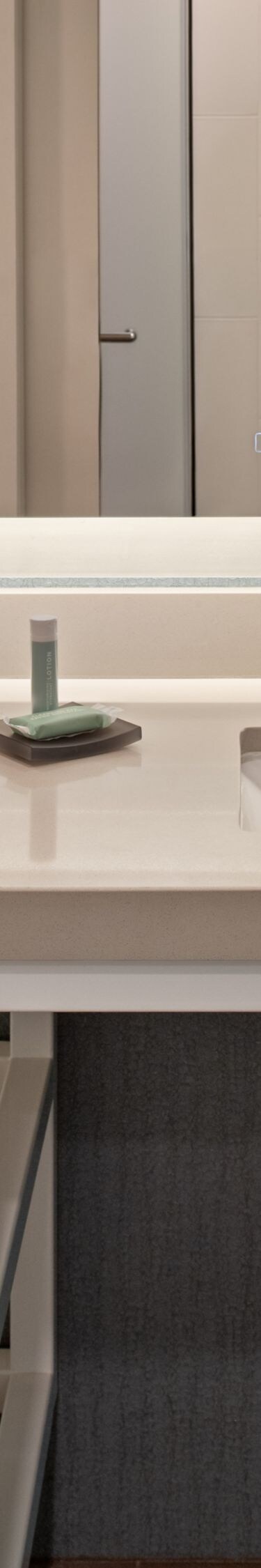 Vanity, tub, towels, toiletries in guest bathroom