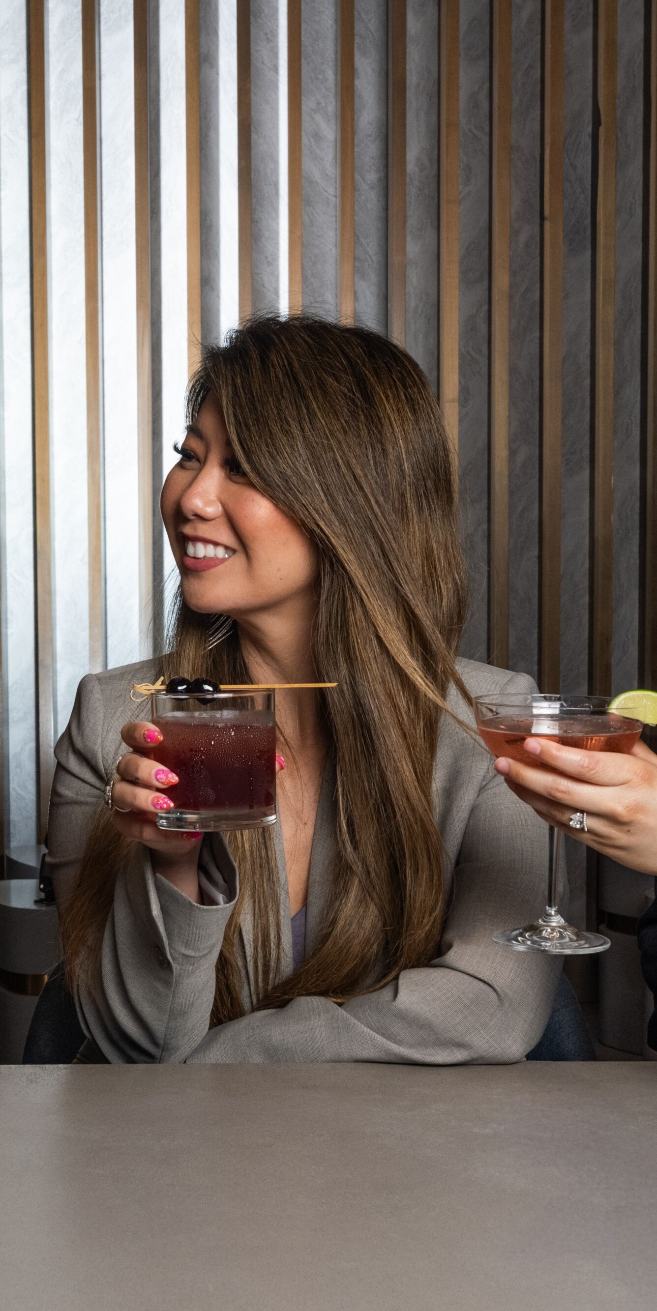 Three guests raise cocktails at hotel bar