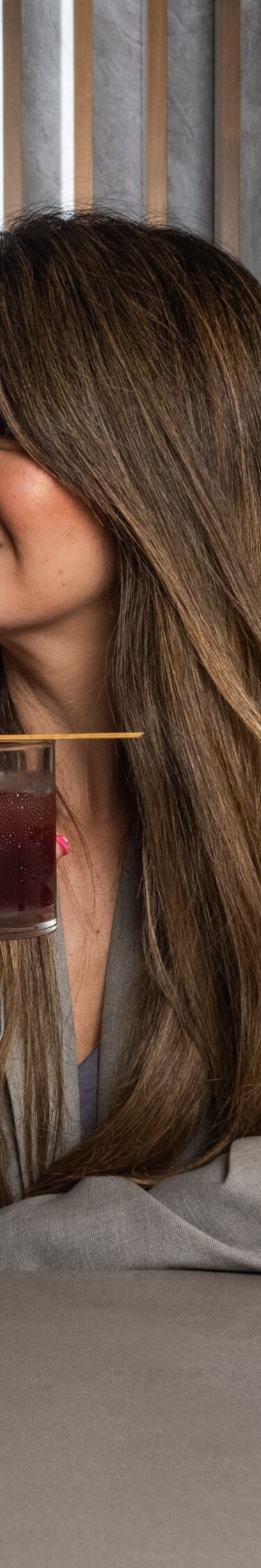 Three guests raise cocktails at hotel bar