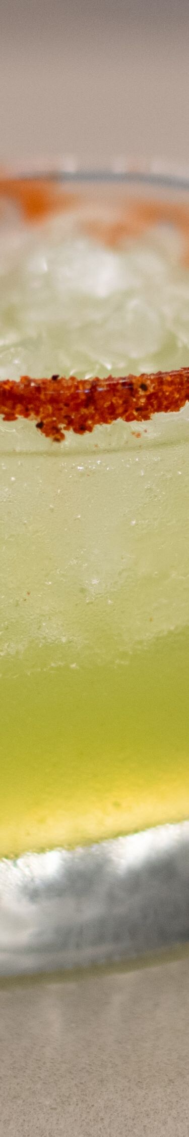 Green margarita cocktail with red chili rim