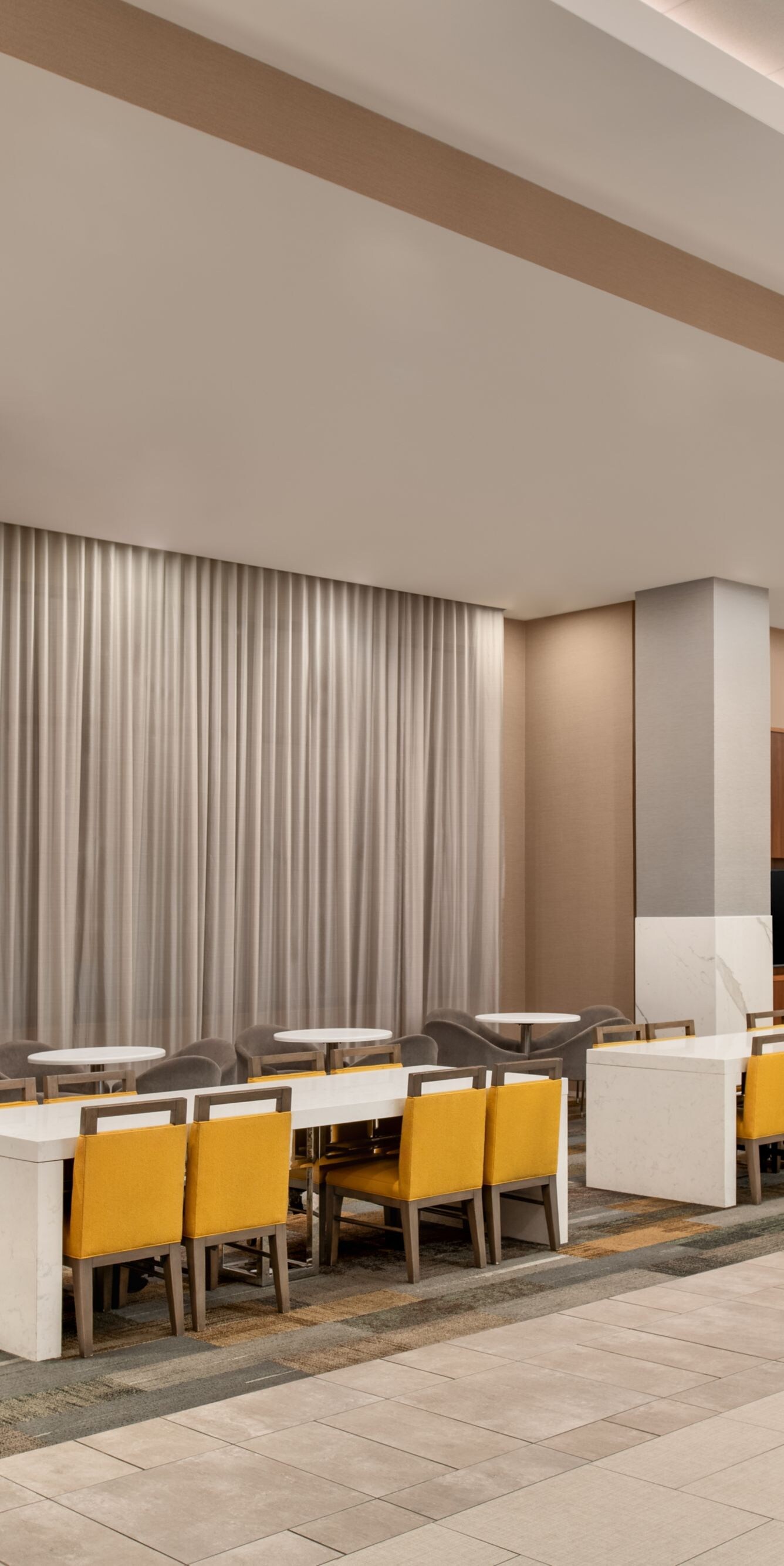 Workspaces and tables near lobby windows