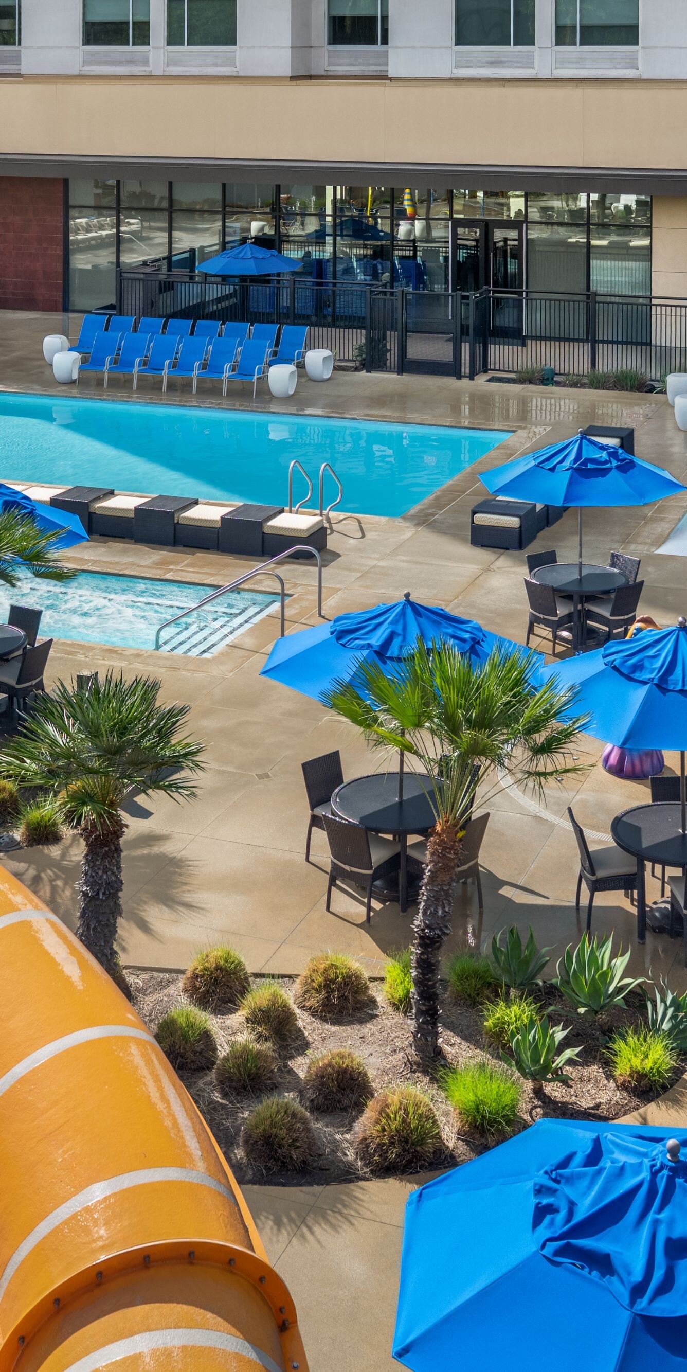 Aerial view of pools, pool seating, and slide
