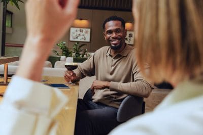 Guest enjoying a glass of red wine with colleague