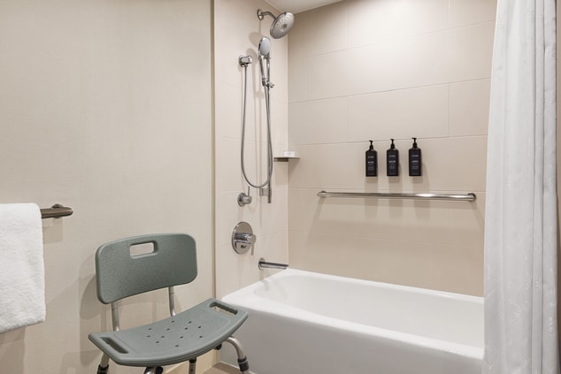 ADA washroom with bathtub and shower chair