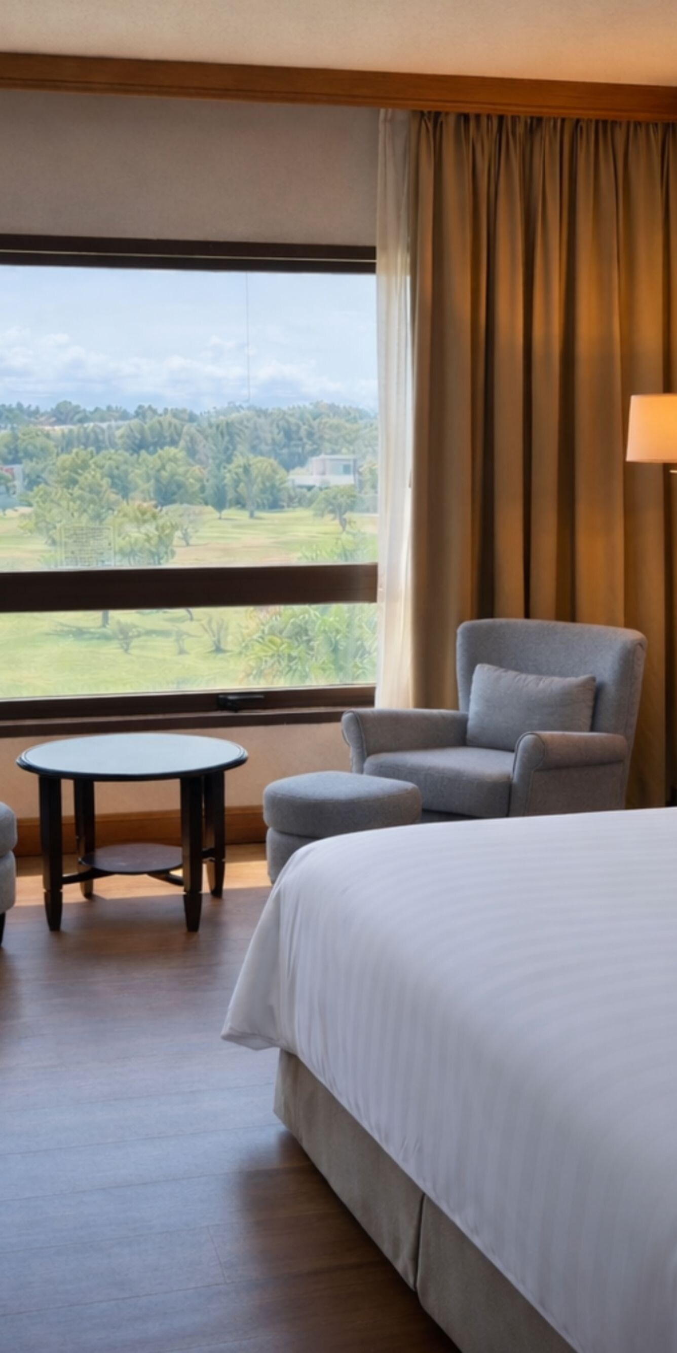 king bed, table with armchairs, golf course view