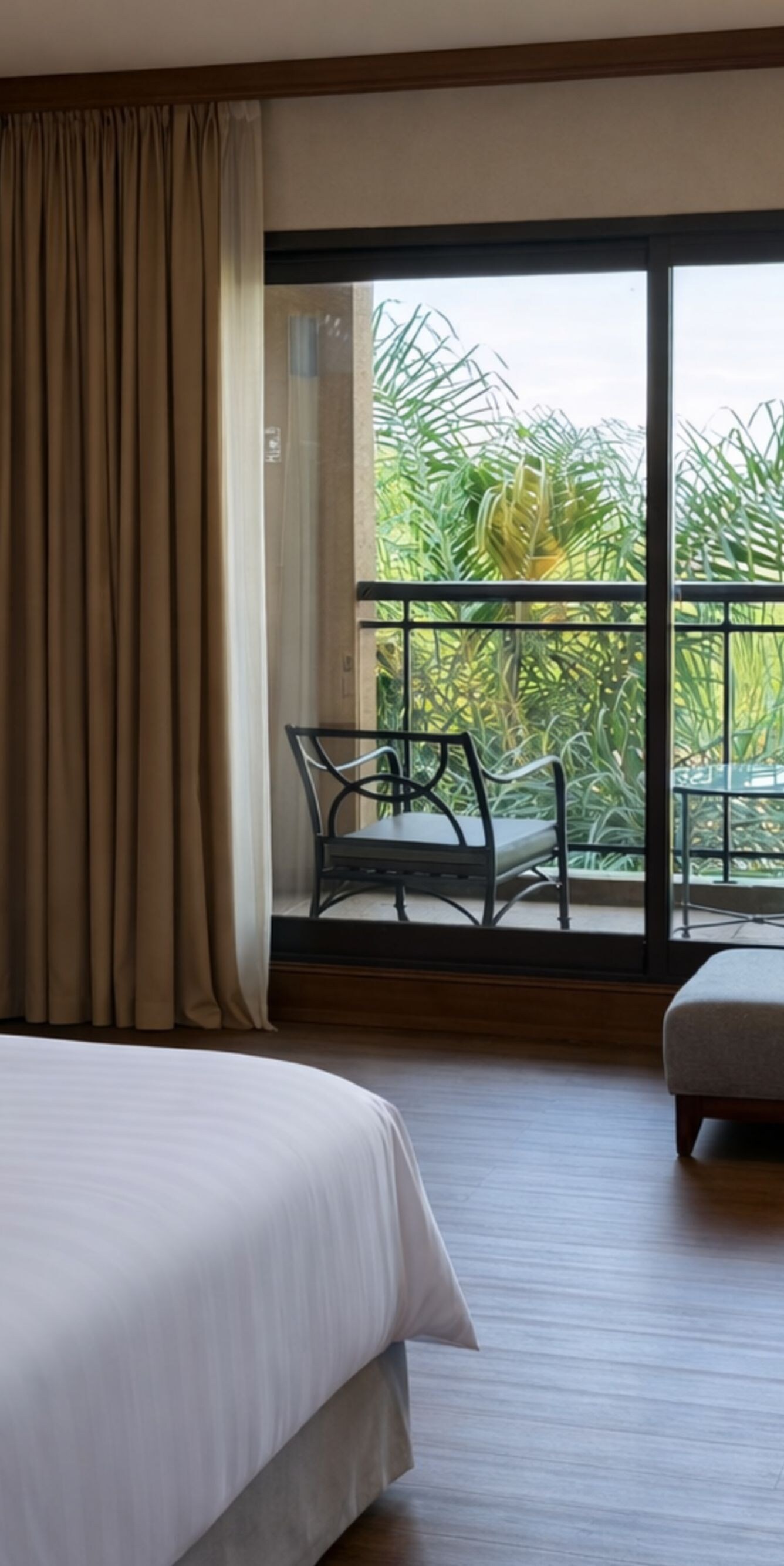 bed, armchair, ottoman, lamps, and balcony