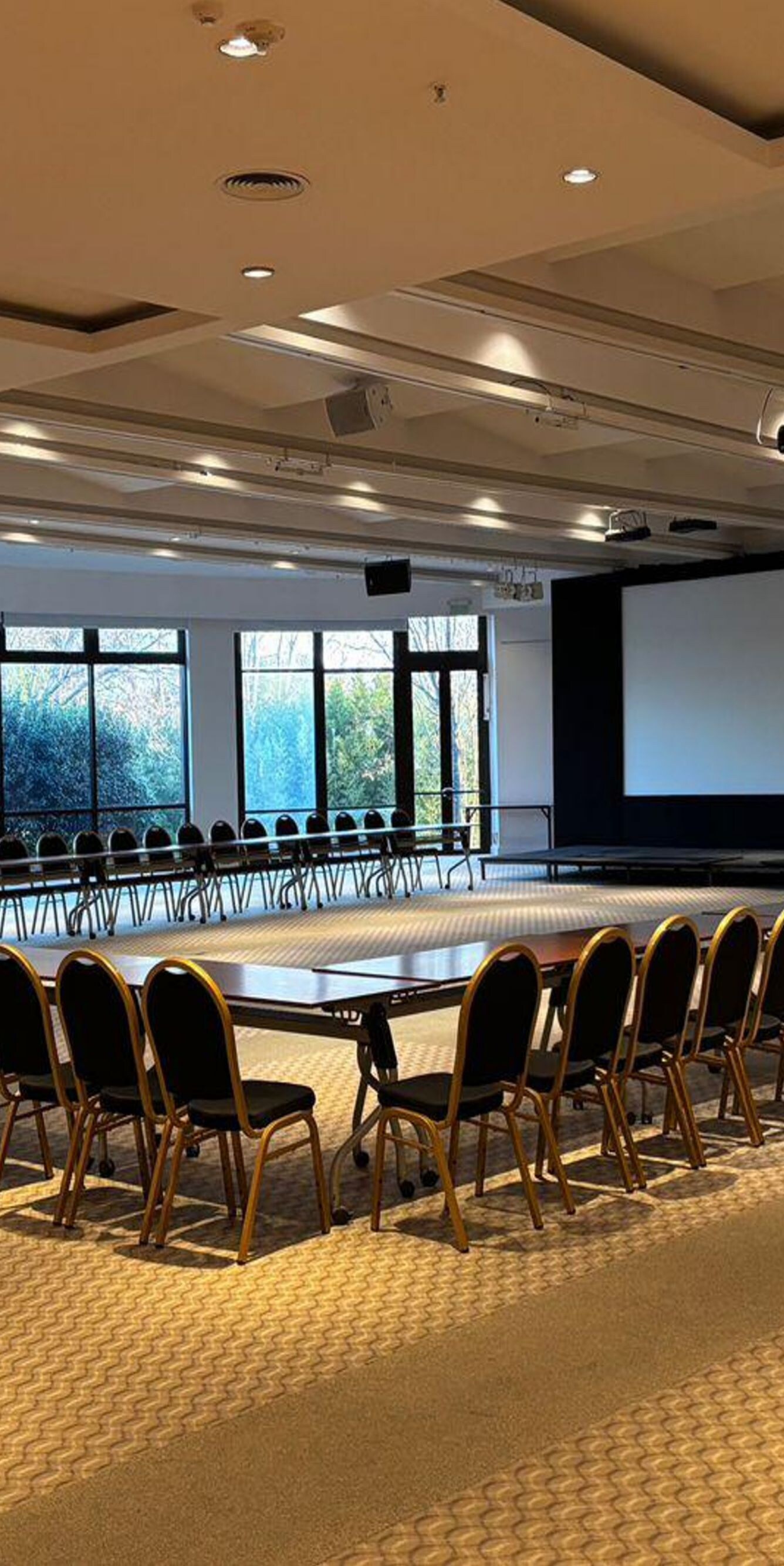 U-shaped conference table with chairs and screen