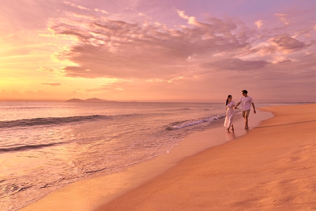 Couple beach walk under sunset