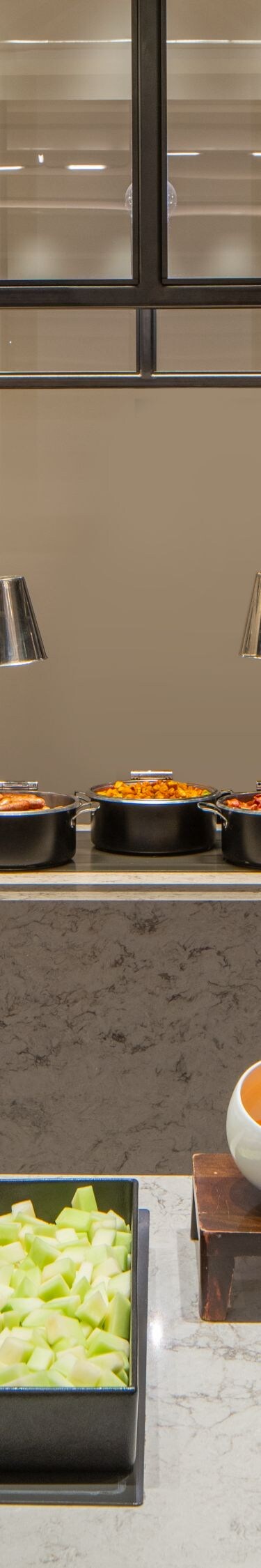 Breakfast buffet with muffins, fruit, eggs, bacon