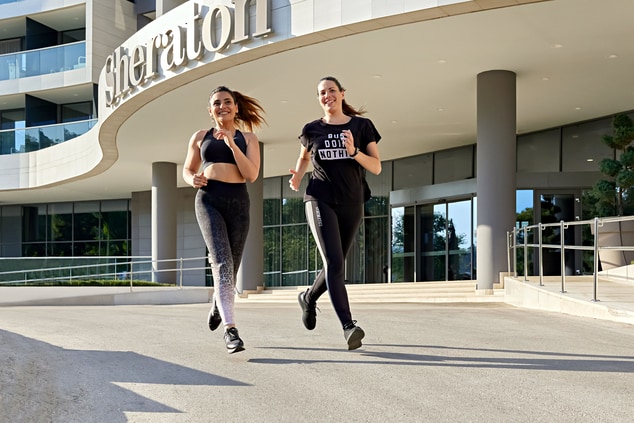 There are two women jogging in front of a building